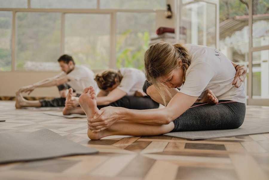 Professeure de yoga ajustant une élève en cours privé